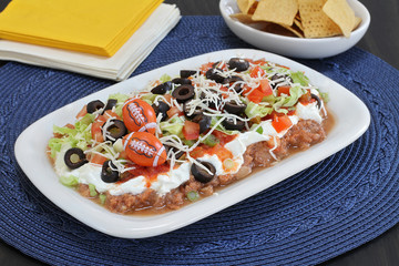 Mexican layered ground beef and bean dip decorated in a masculine way for Dad.
