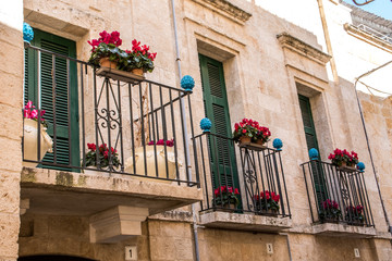Balkone an pittoresken Häusern mit Blumenkästen und Pumo Keramik