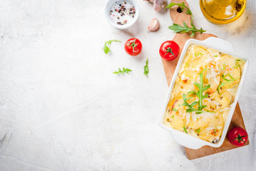 Casserole. French cuisine. Homemade potato gratin in a ceramic frying pan for baking. On a white...