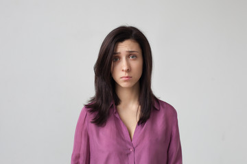 Obraz premium Sleepy girl in pink pajama looks at camera