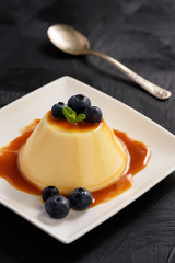 Cream pudding with caramel sauce and blueberries.