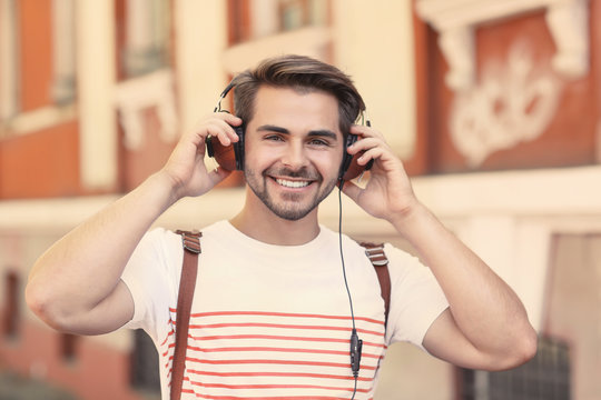 Handsome man with headphones listening music on street