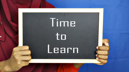 hand teenage girl holding a chalkboard with the words "time to learnl".