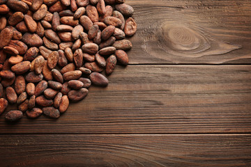 Aromatic cocoa beans on wooden background