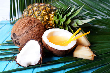 Composition with fresh pineapple, coconut and cocktail on wooden background