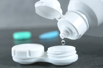 Bottle with lens solution and case on table