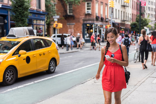 Woman Walking In New York City Using Phone App For Taxi Ride Hailing Service Or Playing Online Game While Commuting From Work. Asian Girl Tourist Searching For Map Directions On Smartphone.