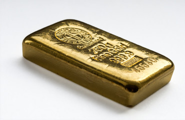 Cast gold bar weighing 250 grams. On a light background. Selective focus..