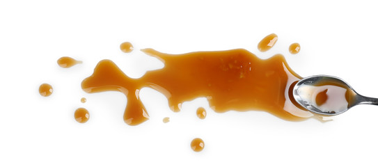 Delicious caramel sauce on white background with spoon