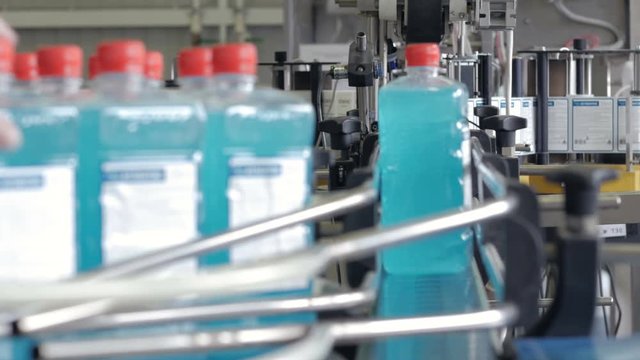 Plastic bottles in production line. Chemical industrial conveyor at work. 4K.