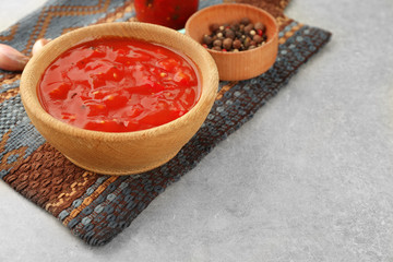 Composition with tasty chili sauce on light background