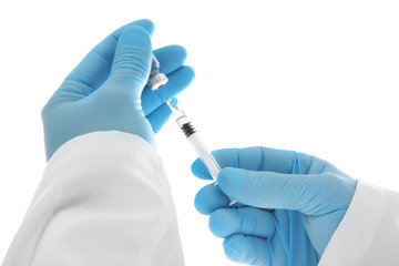Hands of doctor with syringe and medicine on white background, closeup