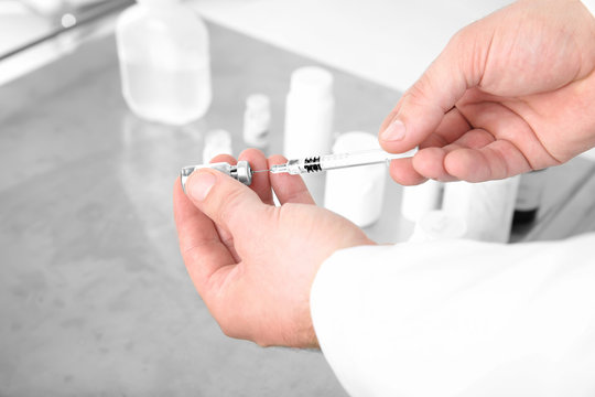 Hands of doctor with syringe and medicine in clinic, closeup