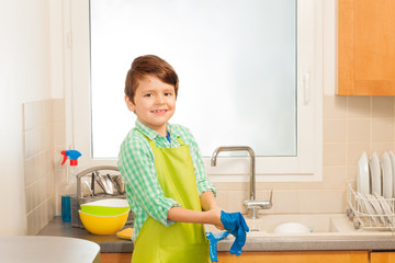 Cute boy wearing rubber gloves before dishwashing