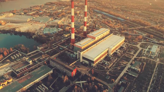 Aerial Drone Flight Footage: main city Power plant with two factory chimneys. Electricity station supply near Dnipro river. Industrial sunset cityscape. Kiev, Ukraine. Top view. Vintage filter toning