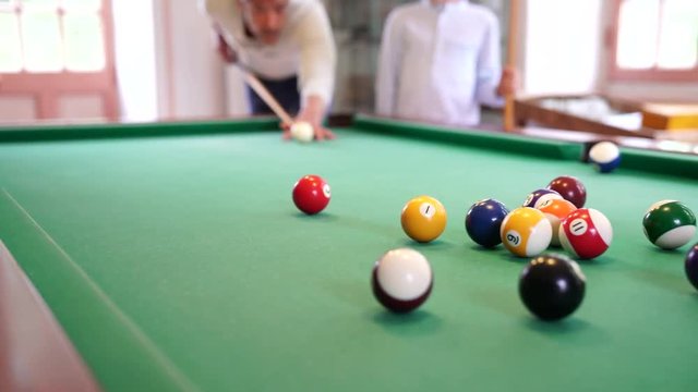 Father and son playing pool together