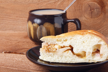 Fresh homemade apple pie and tea with milk on a wooden background