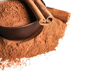 Cinnamon sticks and powder in ceramic bowl isolated on white, closeup