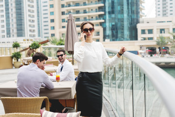 Fototapeta premium Young business woman talking on the phone. Business meeting in progress. Young entrepreneurs.