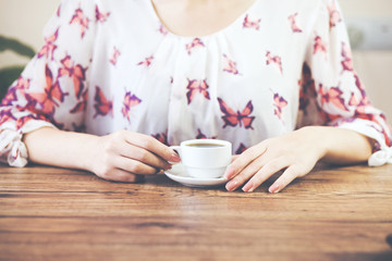 womans hands holding cup of coffee