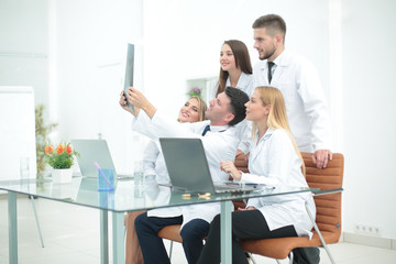 Smiling doctors are analyzind the x-ray. Medical office interior