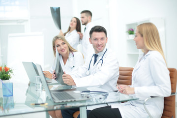 Obraz premium Smiling doctors working at office desk and smiling at camera, me