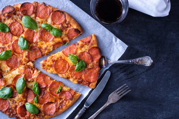 Homemade Pepperoni Pizza over black background. Top view.