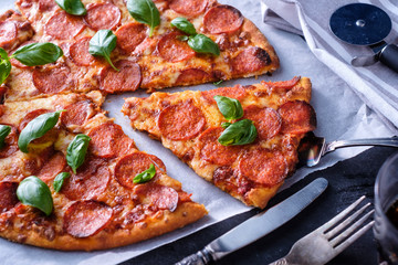 Homemade Pepperoni Pizza over black background. Top view.