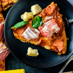 Homemade Pepperoni Pizza with fresh bacon over black background