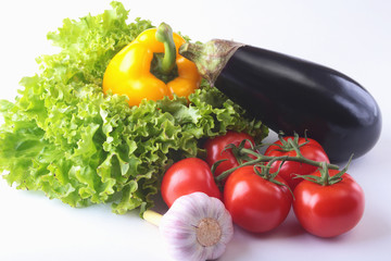 Fresh assorted vegetables, eggplant, bell pepper, tomato, garlic with leaf lettuce. Isolated on white background. Selective focus.