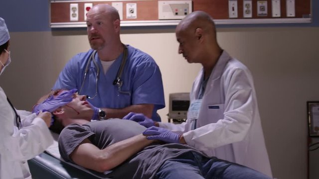 Emergency room doctors examine man with head injury