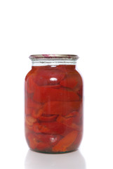Canned red pepper in a glass jar on a white background.