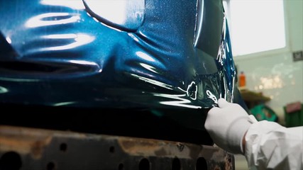 Worker at the service station is further processed edge vinyl by special dryer. Heating is necessary in order to film a few pulled.