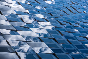 Reflections of cloudy sky on a glass facade