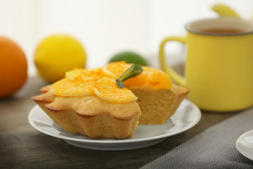 Plate with delicious citrus cake on table