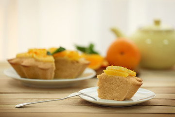 Plate with delicious citrus cake on wooden table