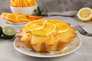 Plate with delicious citrus cake on table