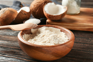 Obraz na płótnie Canvas Coconut flour in bowl on dark wooden table