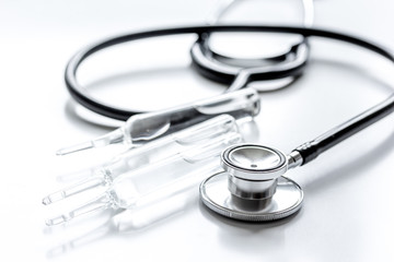 doctor's office table with vials and stethoscope white background