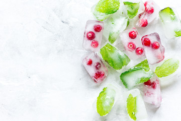 mint and red berries in ice cubes stone background top view mockup