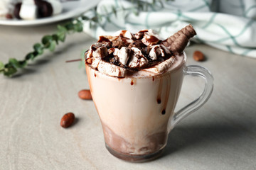 Cup of tasty cocoa drink with marshmallow on table