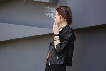 Beautiful young woman smoking weed outdoors