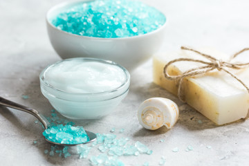 Obraz na płótnie Canvas blue sea salt, soap and body cream on stone desk background