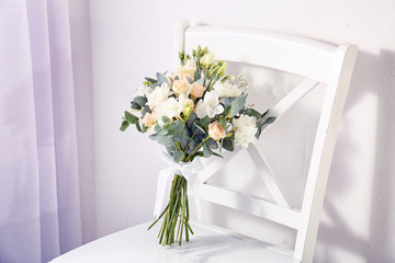 Beautiful bouquet with freesia flowers on chair