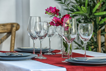 Beautiful festive table setting and flowers in light room