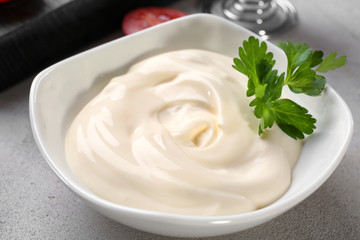Delicious mayonnaise in bowl on kitchen table, closeup