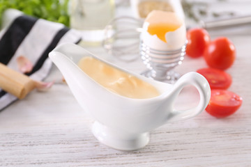 Fototapeta na wymiar Delicious mayonnaise in gravy boat on kitchen table, closeup