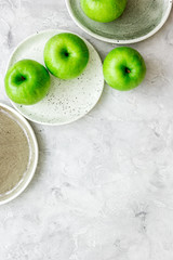 Healthy green food with apples on plates stone background top view mock up