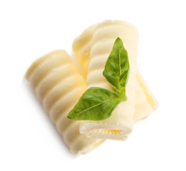 Delicious butter curls and basil leaves on white background, closeup