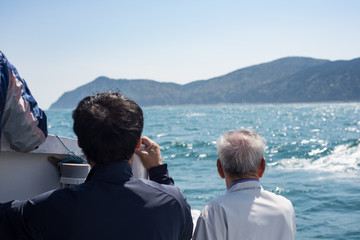 Men on a boat off the shore of Geoje Island, South Korea